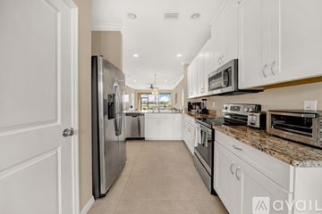 Bradenton condo for rent - A kitchen with white cabinets and appliances.