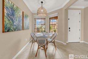 Bradenton condo for rent - A dining room with a table set for four and a painting on the wall.