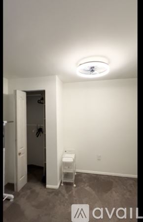 Ellicott City apartment for rent - A shower area with a glass door and a white shower seat.