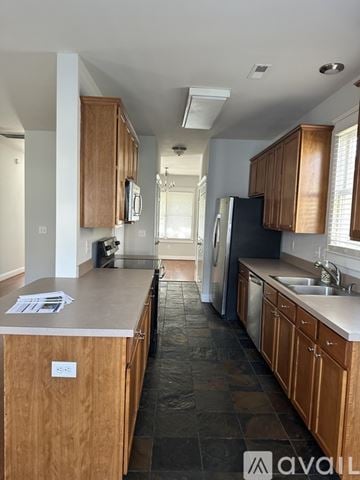 Cary house for rent - A kitchen with wooden cabinets and a black fridge.