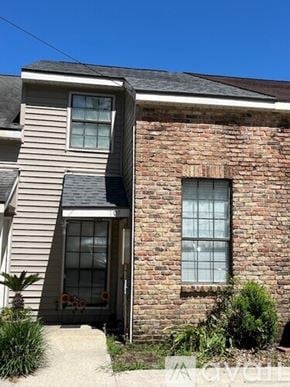 Broussard townhouse for rent - A house with a brick wall and a window.
