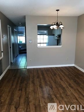 Broussard townhouse for rent - A room with wooden floors and a chandelier.