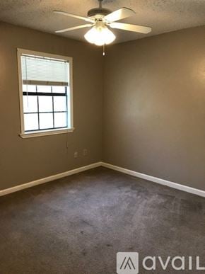 Broussard townhouse for rent - A room with a ceiling fan and a window.