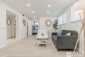 Miami apartment for rent - A living room with a grey couch, a white coffee table, and a wooden floor.