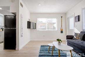 Miami apartment for rent - A living room with a couch, a table, and a TV.