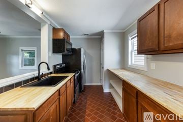Knoxville house for rent - A kitchen with wooden cabinets and a black refrigerator.
