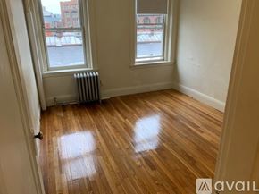 Boston apartment for rent - A room with wooden floors and two windows.