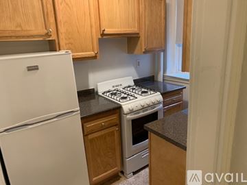 Boston apartment for rent - A kitchen with a white fridge and a white stove top.