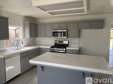 Fresno house for rent - A kitchen with a white countertop and a black oven.