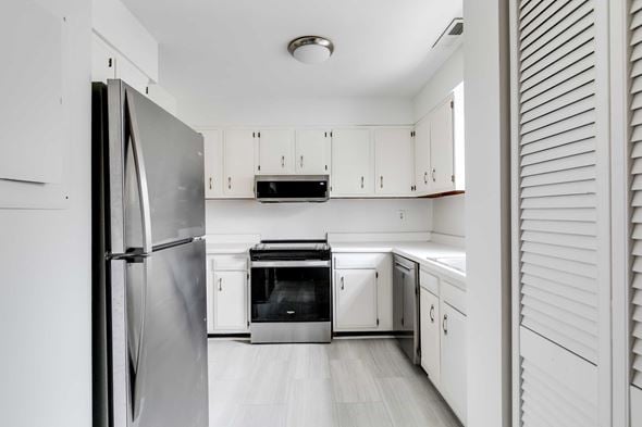 Richmond house for rent - A modern kitchen with white cabinets and a stainless steel refrigerator.