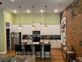 Jonesboro apartment for rent - A kitchen with a table and chairs in front of a brick wall.