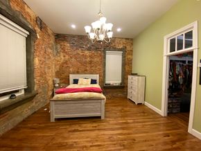 Jonesboro apartment for rent - A bedroom with a bed, dresser, and a chandelier.