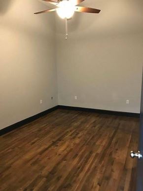 Jonesboro apartment for rent - A room with a ceiling fan and wooden flooring.