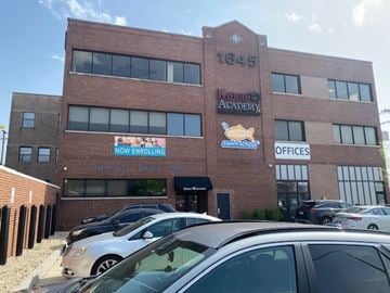 Chicago apartment for rent - A brick building with a sign that says "Now Enrolling" in front of it.