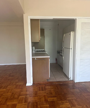 Washington apartment for rent - A kitchen with a white fridge and wooden floors.
