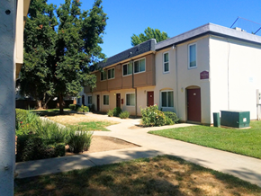 Rancho Cordova apartment for rent - A building with a red door and a green trash can in front of it.