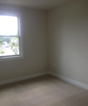 Baltimore house for rent - A room with a window and car parked outside.