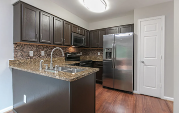 Bowie house for rent - A kitchen with dark brown cabinets and a granite countertop.