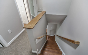 Bowie house for rent - A staircase with a wooden handrail and a carpeted floor.