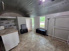 Oklahoma City house for rent - A room with a white refrigerator, a black ottoman, and a whiteboard.