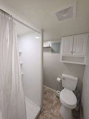 Oklahoma City house for rent - A white toilet in a small bathroom with a white shower curtain.