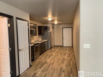 Box Elder apartment for rent - A kitchen with white cabinets and a microwave above the stove.