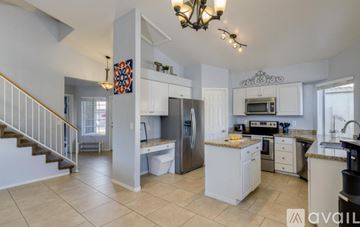 Mesa house for rent - A kitchen with white cabinets and a tiled floor.