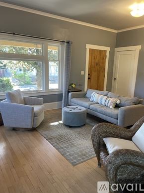 Portland apartment for rent - A living room with a grey sofa, a grey armchair, and a grey ottoman.