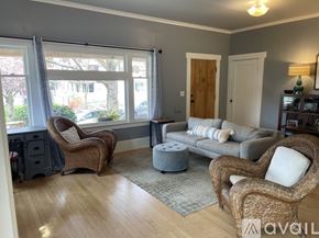 Portland apartment for rent - A living room with a grey couch, two chairs and a small ottoman.