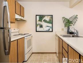 Seattle condo for rent - A kitchen with wooden cabinets and a fridge on the left.