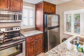 Savannah house for rent - A kitchen with a stove, microwave, refrigerator, and sink.