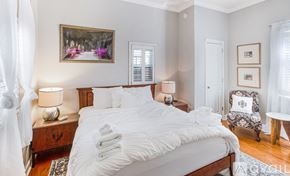 Savannah house for rent - A bedroom with a large bed and a painting on the wall.