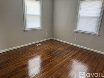 Richmond house for rent - A room with wooden floors and two windows.