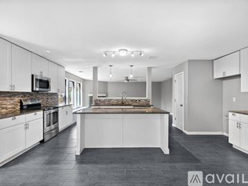 Fort Worth house for rent - A modern kitchen with white cabinets and a central island.