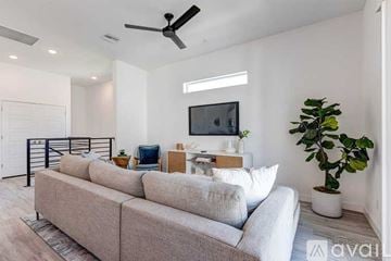 Phoenix apartment for rent - A living room with a grey sofa and a television on the wall.