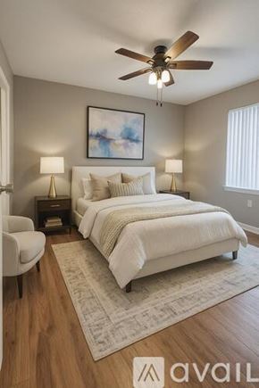 Dallas apartment for rent - A spacious room with grey carpeting and a ceiling fan.