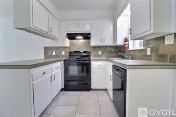 Tulsa apartment for rent - A kitchen with a stove top oven and a black dishwasher.