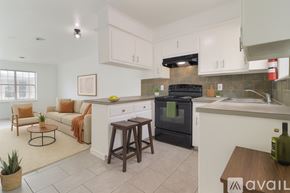 Tulsa apartment for rent - A kitchen with white cabinets and a black refrigerator.