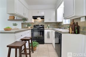 Tulsa apartment for rent - A kitchen with white cabinets and a brick backsplash is on the market.