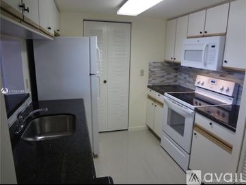 Coral Springs apartment for rent - A kitchen with white cabinets and a black countertop.