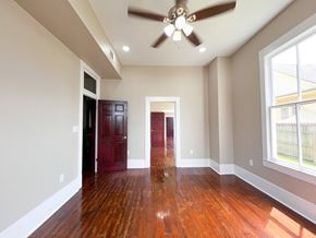Bay City house for rent - A room with a ceiling fan and wooden floors.