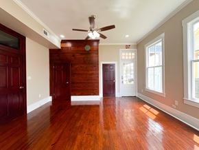 Bay City house for rent - A room with wooden floors and a ceiling fan.