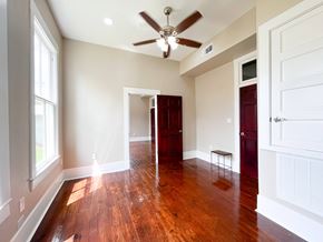 Bay City house for rent - A room with a ceiling fan and wooden floors.