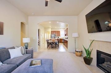 Merced house for rent - A living room with a grey couch and a fireplace.