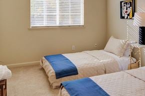 Merced house for rent - A bedroom with two beds and a painting on the wall.