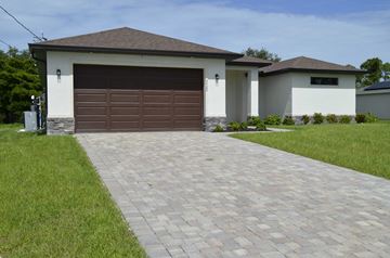 Cape Coral house for rent - A house with a brown garage door and a brick driveway.
