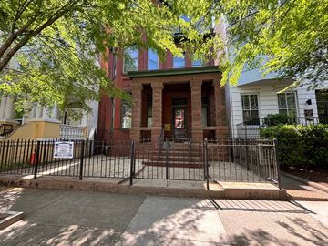 Richmond apartment for rent - A red brick building with a black gate in front.