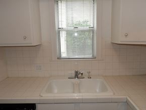 Dallas apartment for rent - A white sink in a white tiled bathroom.
