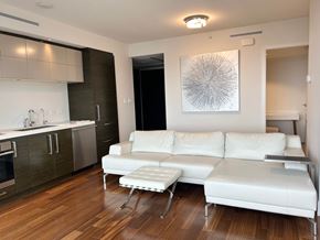 Vancouver house for rent - A white couch sits in a modern kitchen with wood floors.