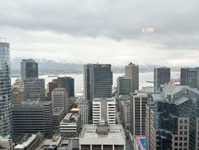 Vancouver house for rent - A cityscape with buildings of various heights and designs under a cloudy sky.